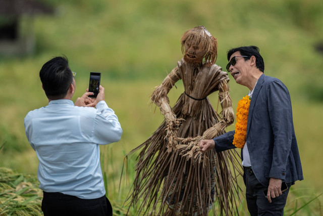 Seorang partisipan berfoto dengan orang-orangan sawah saat field trip World Water Forum ke-10 2024 di kawasan wisata Jatiluwih, Tabanan, Bali, Kamis (23/5/2024). Foto: Bayu Pratama S/ANTARA FOTO