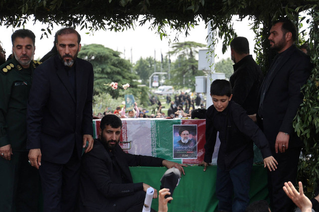 Foto mendiang Presiden Iran Ebrahim Raisi terlihat di peti matinya saat upacara pemakaman di Teheran, Iran, Rabu (22/5/2024). Foto: Majid Asgaripour/WANA via Reuters