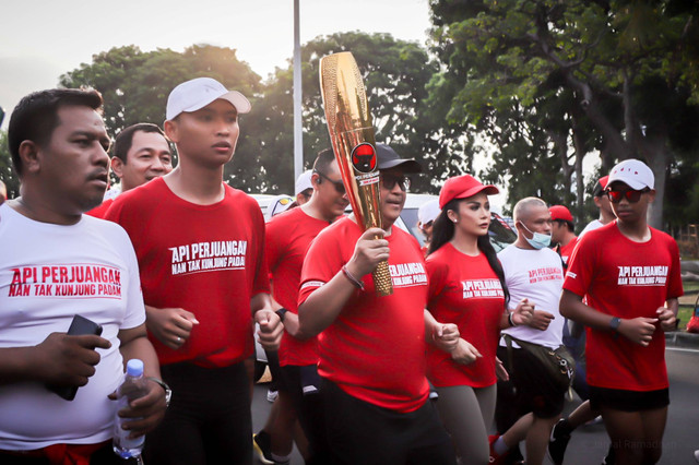 Sekjen PDIP Hasto Kristiyanto berlari sambil memegang obor bersama rombongan pembawa 'Obor Api Perjuangan' di Kemayoran, Jakarta, Kamis (23/5/2024). Foto: Jamal Ramadhan/kumparan