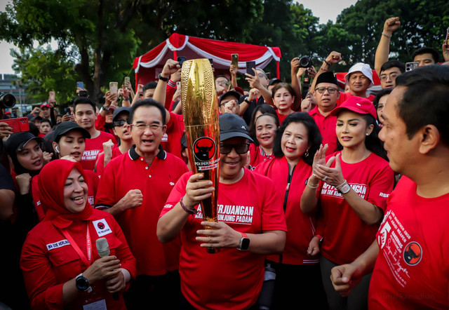 Sekjen PDIP Hasto Kristiyanto berlari sambil memegang obor bersama rombongan pembawa 'Obor Api Perjuangan' di Kemayoran, Jakarta, Kamis (23/5/2024). Foto: Jamal Ramadhan/kumparan