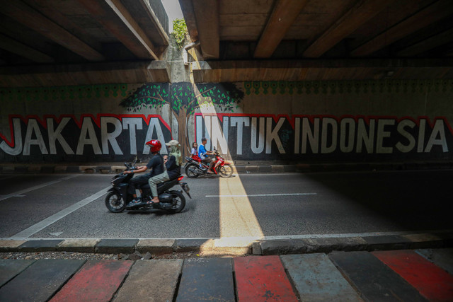 Mural: Sejumlah pengendara sepeda motor melintasi mural bertuliskan "Jakarta untuk Indonesia" di kawasan Bintaro, Jakarta, Senin (20/5). Foto: Aditia Noviansyah/kumparan