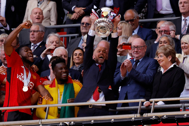 Manajer Manchester United Erik ten Hag mengangkat trofi saat ia merayakan bersama timnya setelah memenangkan Piala FA di Stadion Wembley, London, Inggris, Sabtu (15/5/2024). Foto: Action Images via Reuters/Andrew Couldridge