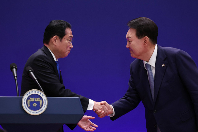 Presiden Korea Selatan Yoon Suk Yeol berjabat tangan dengan Perdana Menteri Jepang Fumio Kishida saat konferensi pers bersama di Seoul, Korea Selatan (27/5/2024). Foto: Kim Hong-Ji/Pool via REUTERS