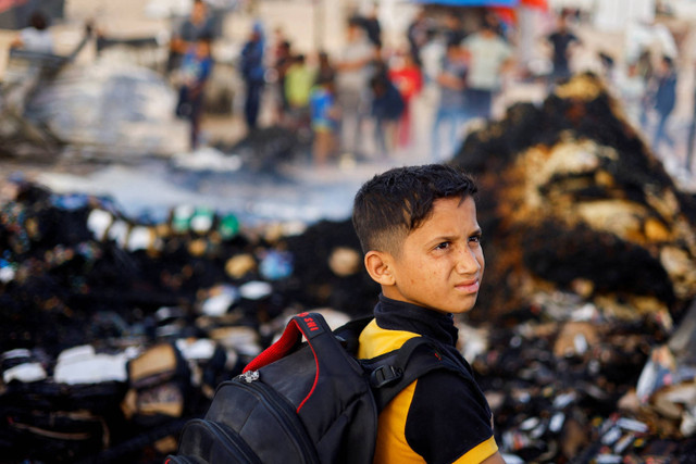 Seorang anak melihat lokasi usai serangan Israel di daerah yang diperuntukkan bagi para pengungsi di Rafah, Jalur Gaza selatan, Senin (27/5/2024). Foto: Mohammed Salem / REUTERS