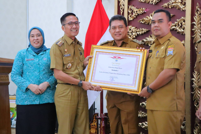 Pj Wali Kota Palembang, Ratu Dewa, saat memberi penghargaan kepada lurah berprestasi. (ist)