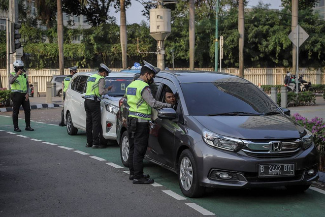 Petugas kepolisian lalu lintas menilang pengendara yang melanggar aturan lalu lintas di kawasan Bundaran Hotel Indonesia, Jakarta, Selasa (16/5/2023). Foto: Jamal Ramadhan/kumparan