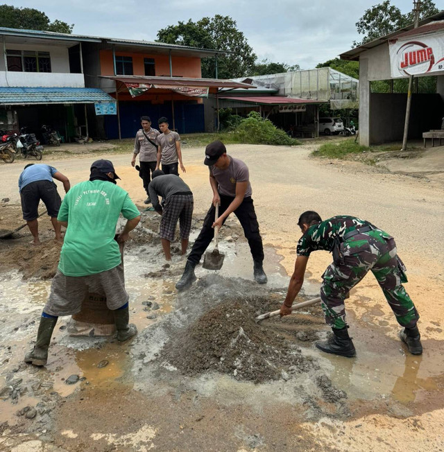 TNI-Polri dan Pemdes Nanga Mahap menambal jalan rusak. Foto: Dok. Polres Sekadau