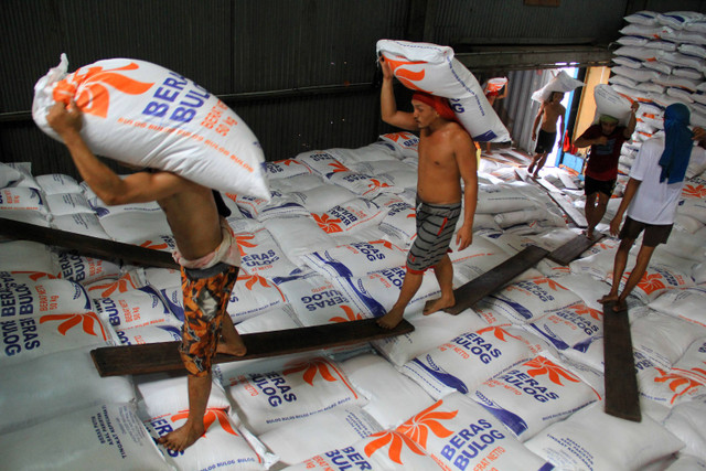 Sejumlah pekerja memikul karung beras di Gudang Bulog, Medan, Sumatera Utara, Selasa (28/5/2024). Foto: Yudi Manar / ANTARA FOTO