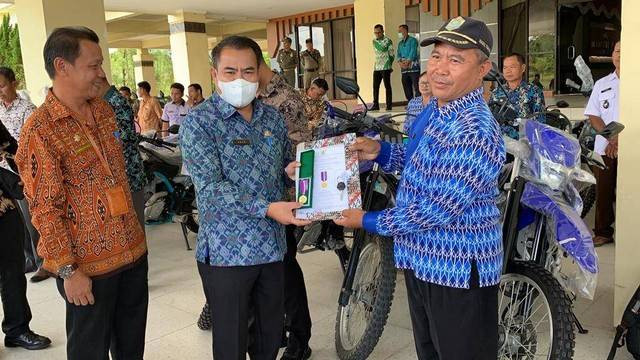 Bupati Sekadau, Aron, menyerahkan penghargaan kepada Kepala Desa Tanjung yang berhasil menjadikan desanya sebagai Desa Mandiri beberapa waktu lau. Foto: Dok. Hi!Pontianak