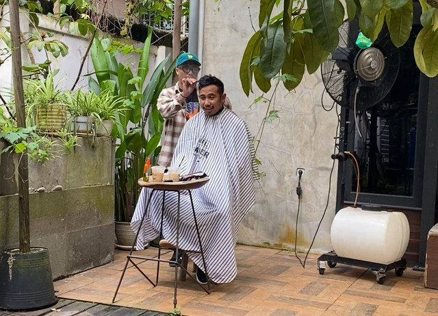 Muhammad Reza saat memangkas rambut pelanggannya di coffe shop. Foto: Yulia Ramadhiyanti/Hi!Pontianak