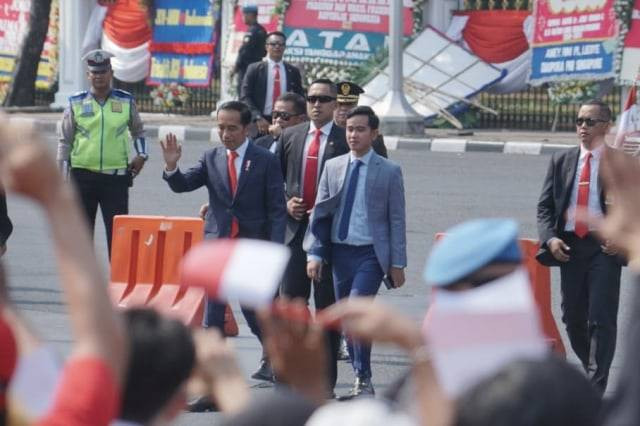 Presiden Joko Widodo dan anaknya Gibran Rakabuming Raka menyapa masyarakat dan pendukungnya di depan Istana Negara, Jakarta, Minggu (20/10). Foto: Helmi Afandi Abdullah/kumparan