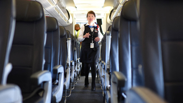 Pramugari terlama American Airlines, Bette Nash, 81 tahun, memeriksa kursi penumpang di Bandara Ronald Reagan Washington di Arlington, Virginia pada 19 Desember 2017. Foto: ERIC BARADAT / AFP