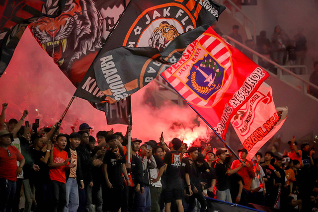 Suporter menyalakan flare saat Persija Jakarta melawan PSIS Semarang dalam pertandingan RCTI Premium Sport di Jakarta International Stadium (JIS), Jakarta, Kamis (30/5/2024). Foto: Jamal Ramadhan/kumparan