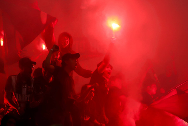 Suporter menyalakan flare saat Persija Jakarta melawan PSIS Semarang dalam pertandingan RCTI Premium Sport di Jakarta International Stadium (JIS), Jakarta, Kamis (30/5/2024). Foto: Jamal Ramadhan/kumparan