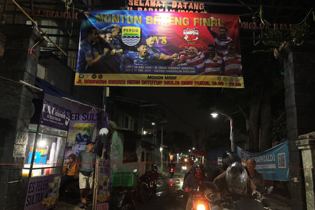 Warga Jalan Babakan Irigasi, Kelurahan Babakan Tarogong, Kecamatan Bojongloa Kaler tutup jalan demi gelar nobar laga final Persib Bandung vs Madura United, Jumat (31/5/2024). Foto: Robby Bouceu/kumparan