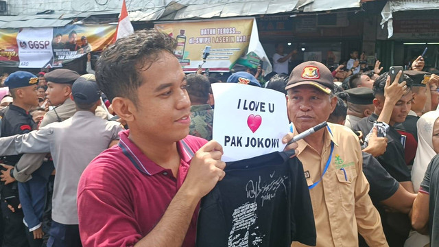 Warga Dumai, Riau mendapatkan kaos dan tanda tangan dari Presiden Jokowi di Pasar Senggol, Dumai, Riau, Sabtu (1/6). Foto: Fadlan Nuril Fahmi/kumparan