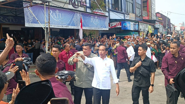 Presiden Jokowi membagikan kaos kepada warga di Pasar Senggol, Dumai, Riau, Sabtu (1/6). Foto: Fadlan Nuril Fahmi/kumparan