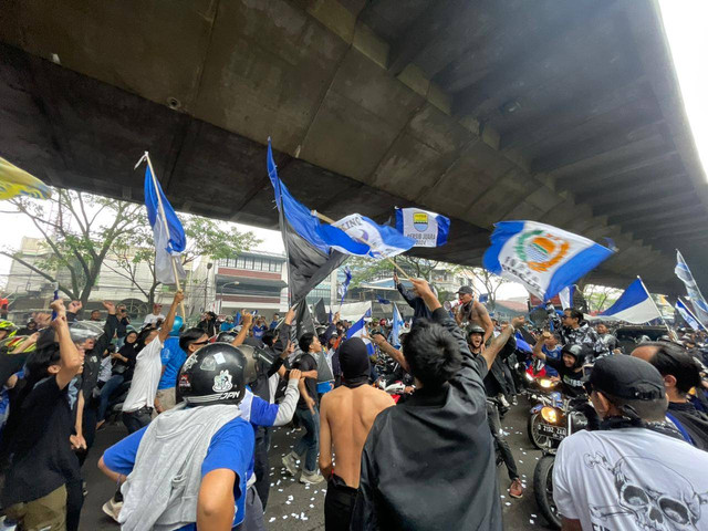 Suporter Persib Bandung tampak tumpah ruah ke jalan sambil menunggu arak-arakan pemain Persib setelah berhasil juara liga 1, Sabtu (1/6). Foto: Robby Bouceu/kumparan