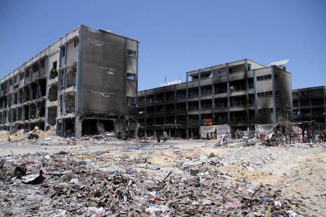 Warga Palestina memeriksa kerusakan di sekolah yang berafiliasi dengan UNRWA, setelah pasukan Israel mundur dari kamp pengungsi Jabalia, menyusul penggerebekan, di Jalur Gaza utara, Jumat (31/5/2024). Foto: Mahmoud Issa/REUTERS