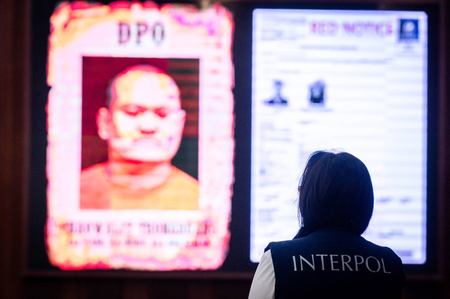 Seorang polisi berada didekat layar yang menampilkan gambar buronan Interpol Thailand Chaowalit Thongduang saat konferensi pers penangkapan buronan Interpol Thailand di Gedung Bareskrim Polri, Jakarta, Minggu (2/6/2024). Foto: Bayu Pratama S/ANTARA FOTO