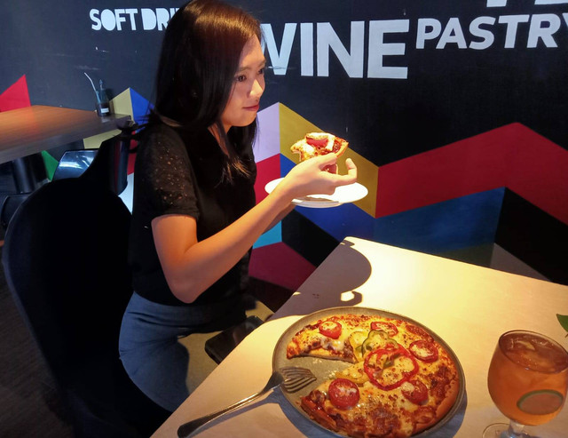 Menikmati pizza Italia dengan topping rendang. Foto: Masruroh/Basra