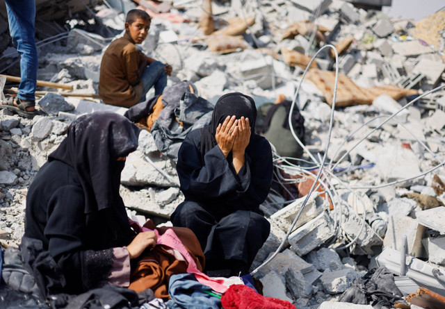 Warga Palestina bereaksi ketika mereka memeriksa lokasi serangan Israel di sebuah rumah di tengah konflik yang sedang berlangsung antara Israel dan Hamas, di Khan Younis di selatan Jalur Gaza (3/6/2024). Foto: Mohammed Salem / REUTERS