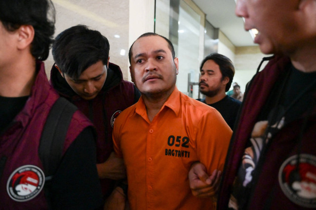 Petugas menggiring buronan bandar narkoba Thailand Chaowalit Thongduang (tengah) menuju mobil tahanan saat proses ekstradisi di Gedung Bareskrim, Jakarta, Selasa (4/6/2024). Foto: BAY ISMOYO / AFP