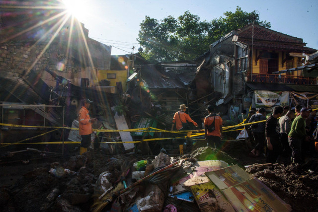 Warga dibantu petugas kepolisian mengevakuasi barang di rumah yang rusak akibat jebolnya pipa milik PDAM Tirtawening di Cibangkong, Bandung, Jawa Barat, Kamis (6/6/2024). Foto: Novrian Arbi/ANTARA FOTO