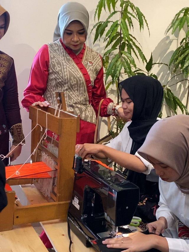 Ketua Dekranasda Kalbar, Windy Prihastari melihat siswi SMKN 6 Pontianak yang sedang membuat kain tenun untuk selendang. Foto: Yulia Ramadhiyanti/Hi!Pontianak