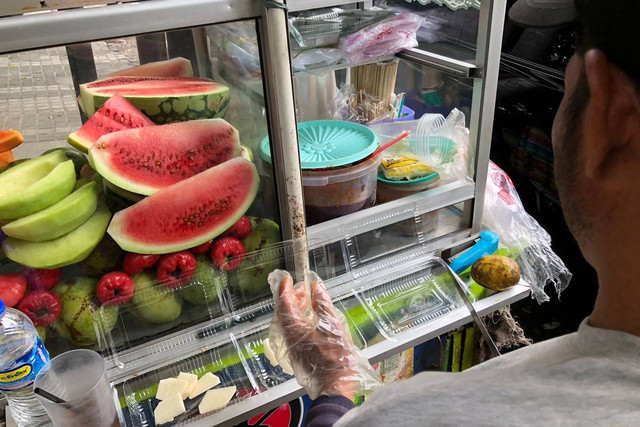 Surya (47), penjual rujak yang dagangannya laris akibat digelarnya aksi solidaritas untuk Palestina, di jalan Diponegoro, Bandung, Sabtu (8/6/2024). Foto: Robby Bouceu/kumparan