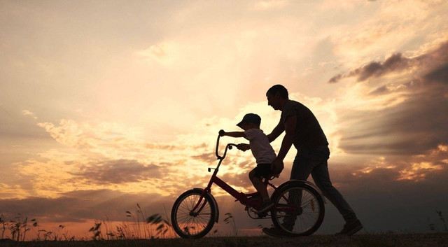 Seorang Ayah yang mengajari anaknya bermain sepeda (Sumber: Shutterstock)