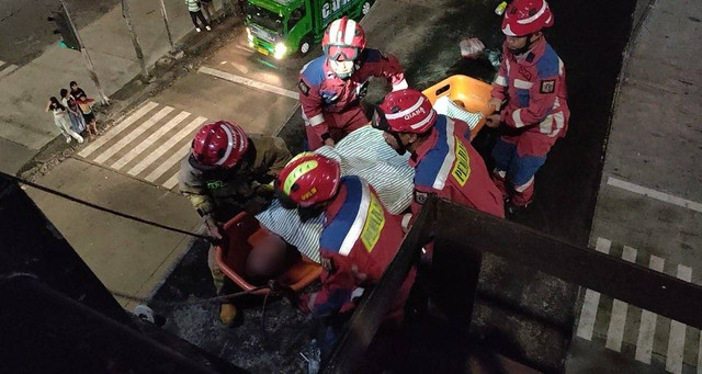 Anggota damkar mengevakuasi pria yang lakukan percobaan bunuh diri di flyover Pasar Rebo, Jaktim, Minggu (10/6). Foto: X/@humasjakfire