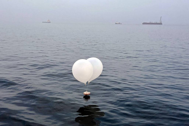 Sebuah balon yang membawa berbagai benda termasuk sampah, yang diyakini dikirim oleh Korea Utara, terlihat di laut lepas Incheon, Korea Selatan, Minggu (9/6/2024). Foto: Yonhap/via REUTERS 