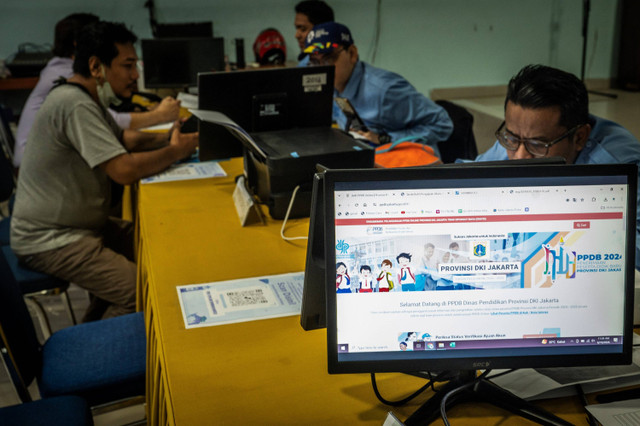 Petugas membantu orang tua murid dan calon peserta didik baru melakukan pengecekan status pendaftaran Penerimaan Peserta Didik Baru (PPDB) di Posko Pelayanan PPDB, Jakarta, Senin (10/6/2024). Foto: Bayu Pratama S/ANTARA FOTO