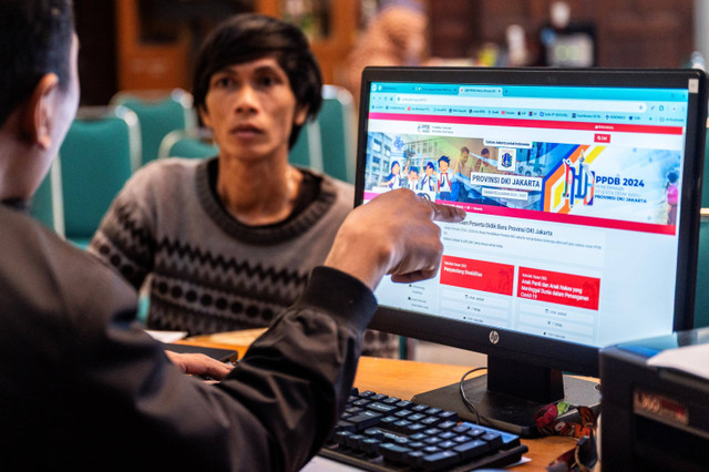 Petugas membantu orang tua murid melakukan pengecekan status pendaftaran Penerimaan Peserta Didik Baru (PPDB) di Posko Pelayanan PPDB, Jakarta, Senin (10/6/2024). Foto: Bayu Pratama S/ANTARA FOTO