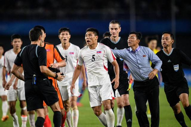 Wasit Rustam Lutfullin saat memimpin pertandingan antara Jepang dan Korea Utara di Asian Games 2022.  Foto: Aamir QURESHI/AFP