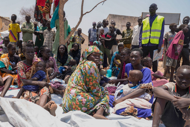 Warga Sudan Selatan yang melarikan diri dari Sudan duduk di luar klinik nutrisi di pusat transit di Renk, Sudan Selatan, (16/5/2023). Foto: Sam Mednick/AP Photo