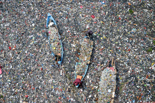 Petugas dengan menggunakan perahu kayu membersihkan sampah Sungai Citarum di Batujajar, Kabupaten Bandung Barat, Jawa Barat, Rabu (12/6/2024). Foto: Raisan Al Farisi/ANTARA FOTO