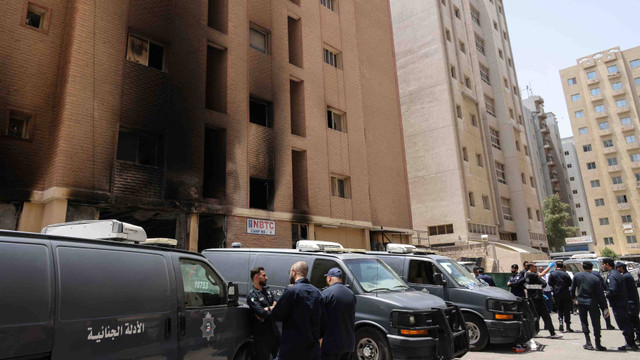 Pasukan keamanan Kuwait berkumpul di luar sebuah gedung yang dilalap api, di Kota Kuwait, pada 12 Juni 2024. 
 Foto:  YASSER AL-ZAYYAT/AFP