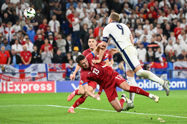 Pemain Timnas Inggris Harry Kane berebut bola dengan pemain Timnas Serbia Milos Veljkovic pada pertandingan Grup C Piala Eropa 2024 di Arena AufSchalke, Gelsenkirchen, Jerman, Senin (17/6/2024). Foto: ALBERTO PIZZOLI / AFP