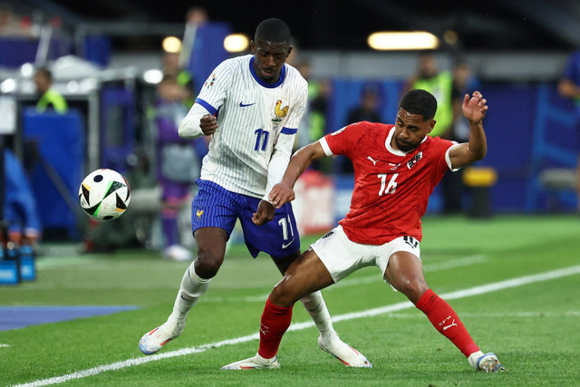 Pemain Timnas Prancis Ousmane Dembele berebut bola dengan pemain Timnas Austria Philipp Mwene pada pertandingan Grup D Piala Eropa 2024 di Duesseldorf Arena, Duesseldorf, Jerman, Senin (17/6/2024). Foto: FRANCK FIFE / AFP