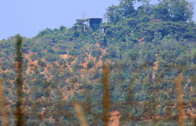 Sebuah fasilitas (atas C) yang diyakini sebagai pengeras suara Korea Utara terlihat di puncak bukit di Korea Utara dilihat dari Pulau Ganghwa Korea Selatan dekat Zona Demiliterisasi (DMZ) yang membagi kedua Korea, pada 11 Jumi 2024. Foto: YONHAP / AFP