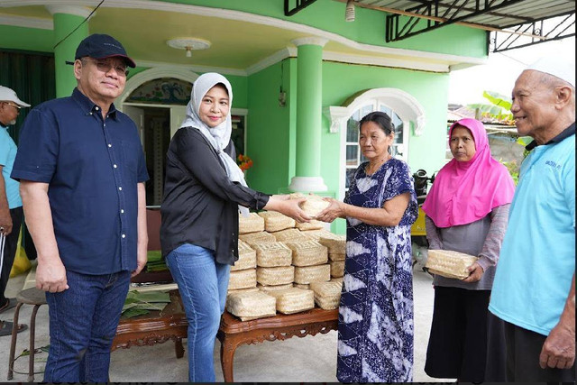 Ketua TP PKK, Windy Prihastari bersama Pj Gubernur Kalbar, Harisson saat membagikan daging kurban ke warga menggunakan wadah dari besek. Foto: Dok. Adpim Pemprov Kalbar