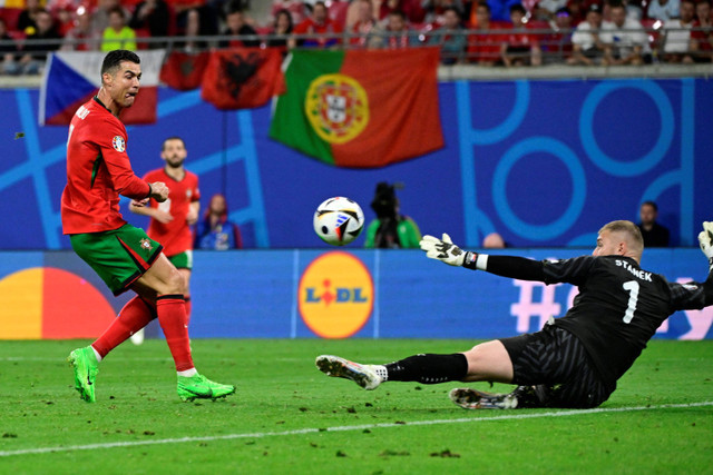 Pemain Timnas Portugal Cristiano Ronaldo menendang bola ke gawang Timnas Republik Ceko pada pertandingan Grup F Piala Eropa 2024 di Red Bull Arena, Leipzig, Jerman, Rabu (19/6/2024). Foto: John MACDOUGALL / AFP