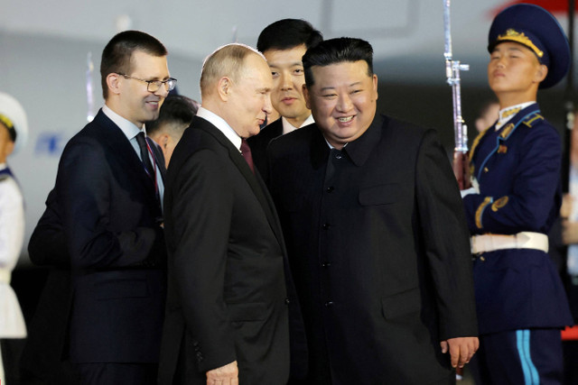 Pemimpin Korea Utara Kim Jong-un menyambut kedatangan Presiden Rusia Vladimir Putin setibanya di bandara Pyongyang, Korea Utara, Selasa (18/6/2024). Foto: KCNA/via REUTERS