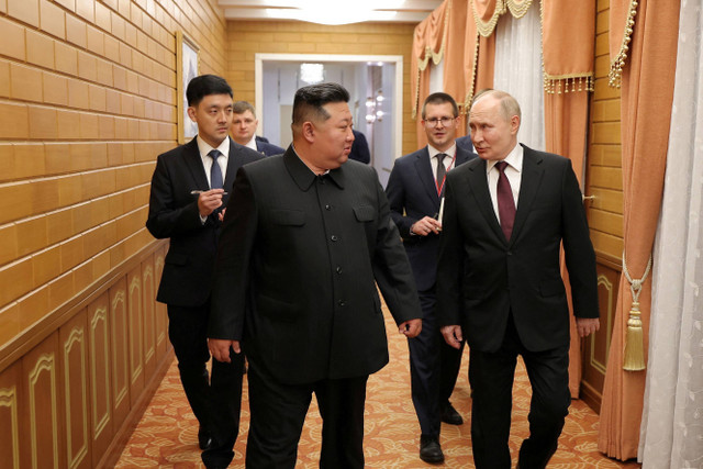 Pemimpin Korea Utara Kim Jong-un berbincang dengan Presiden Rusia Vladimir Putin setibanya di Pyongyang, Korea Utara, Selasa (18/6/2024). Foto: KCNA/via REUTERS