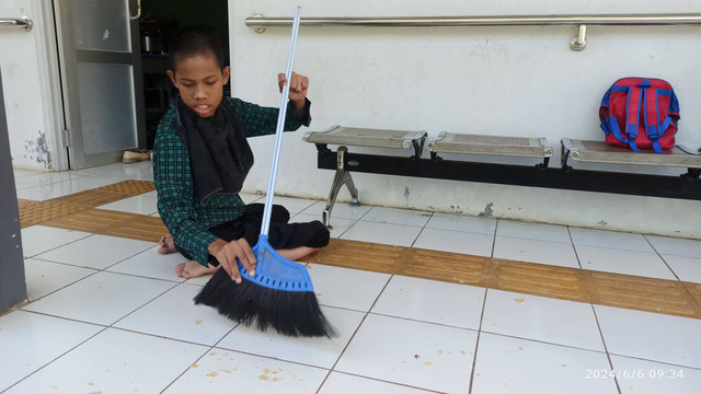 Anak berkebutuhan khusus (ABK) sedang belajar menyapu tanpa bantuan kursi roda (Dokumentasi pribadi)
