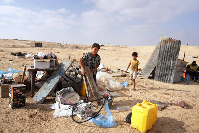 Keluarga-keluarga Palestina yang mengungsi mengemasi barang-barang mereka untuk meninggalkan Rafah menuju Khan Yunis, Kamis (20/6/2024). Foto: Bashar Taleb/AFP