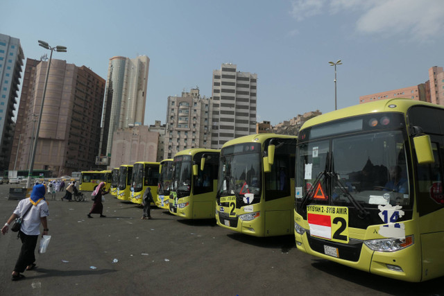 Jamaah haji Indonesia melintas di depan bus Shalawat di Terminal Syib Amir, Makkah, Arab Saudi, Kamis (20/6/2024). Foto: Sigid Kurniawan/ANTARA FOTO 