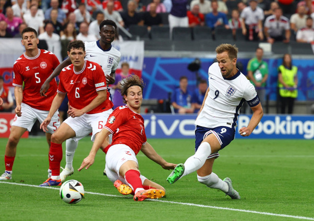 Harry Kane dari Inggris mencetak gol pertama pada laga Denmark melawan Inggris saat Piala Eropa 2024 di Deutsche Bank Park, Jerman, Kamis (20/6/2024). Foto: Lee Smith/REUTERS 